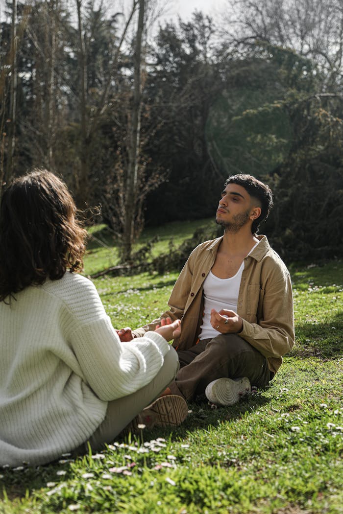 why-choose-us A peaceful moment of a couple meditating on grass in a serene outdoor location.